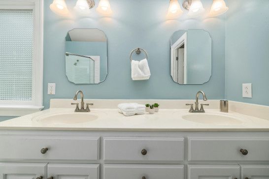 A medicine chest, washbasin, and bathtub with a soap dispenser.