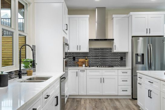 A microwave, refrigerator, dishwasher, and desk in a modern room.