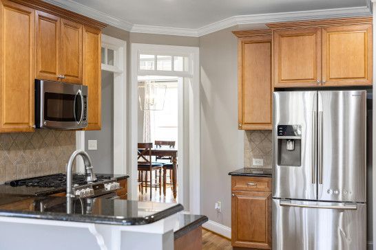 A kitchen with a microwave, refrigerator, dishwasher, paper towel, and stove.