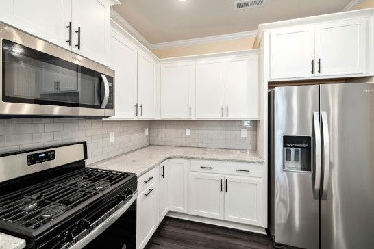 A microwave and refrigerator in a recreational vehicle with a home theater.