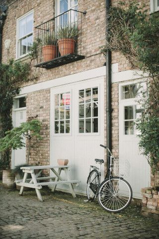 A patio with a bicycle-built-for-two, tricycle, and mobile home.