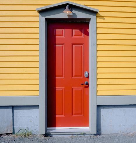 A red front door on a yellow house in Newport, Wales. Expertly painted by Orchid Decor.