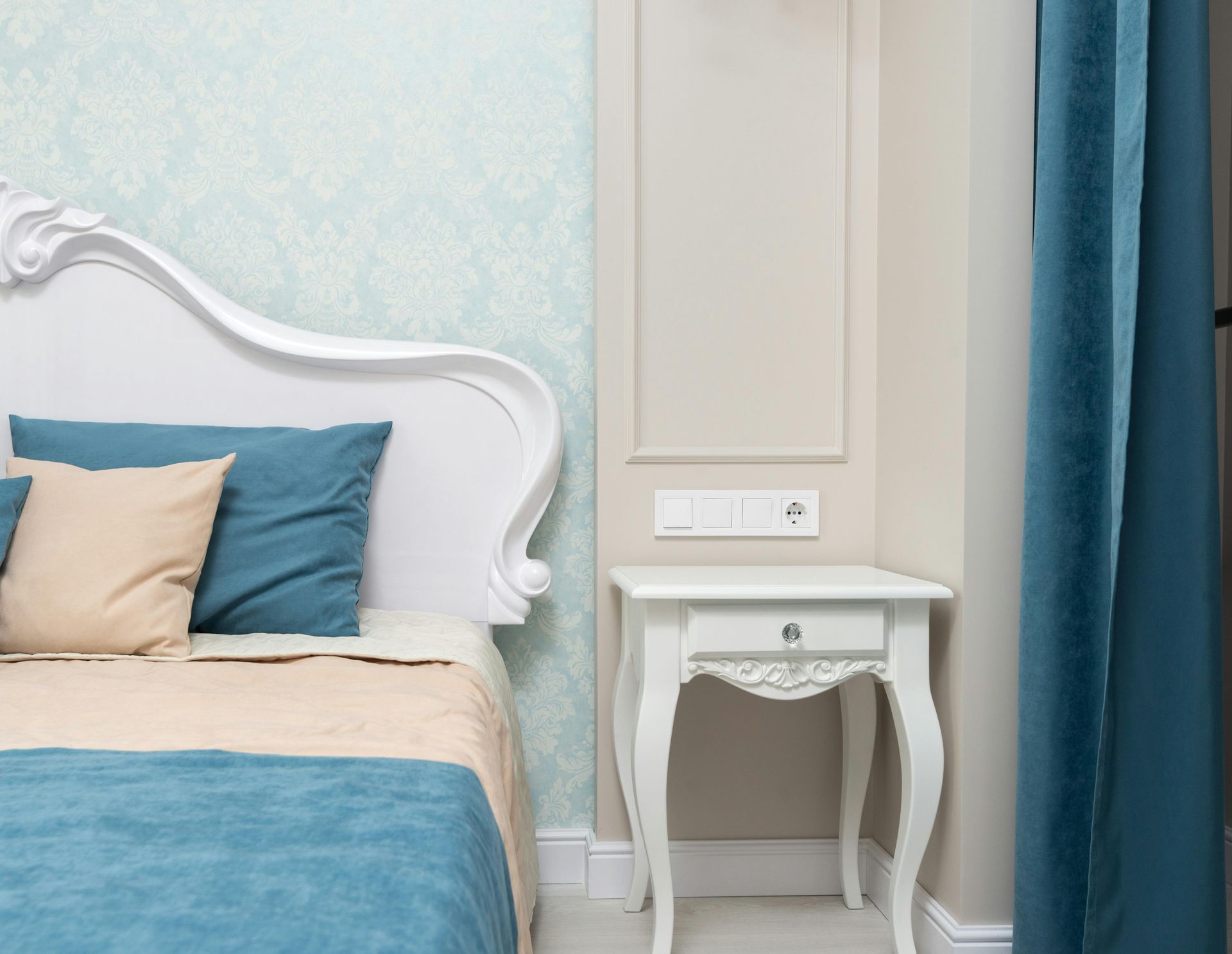 A calm blue styled bedroom in Newport Wales with light blue patterned wallpaper in a timeless style. Completed by Orchid Decor.