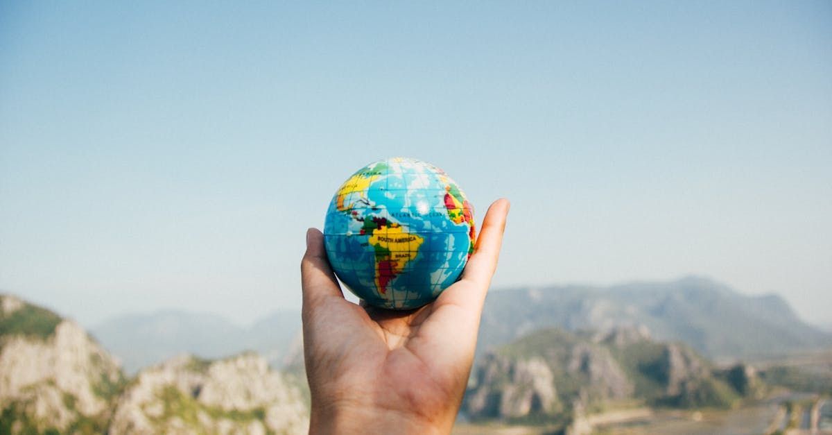 A person is holding a small globe in their hand.