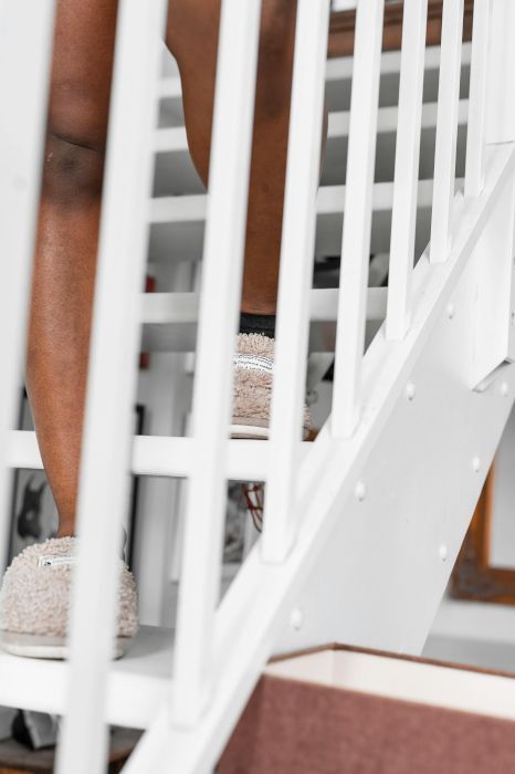 A person standing on a set of stairs with a white railing. Expertly painted by Orchid Decor in Newport, Wales.