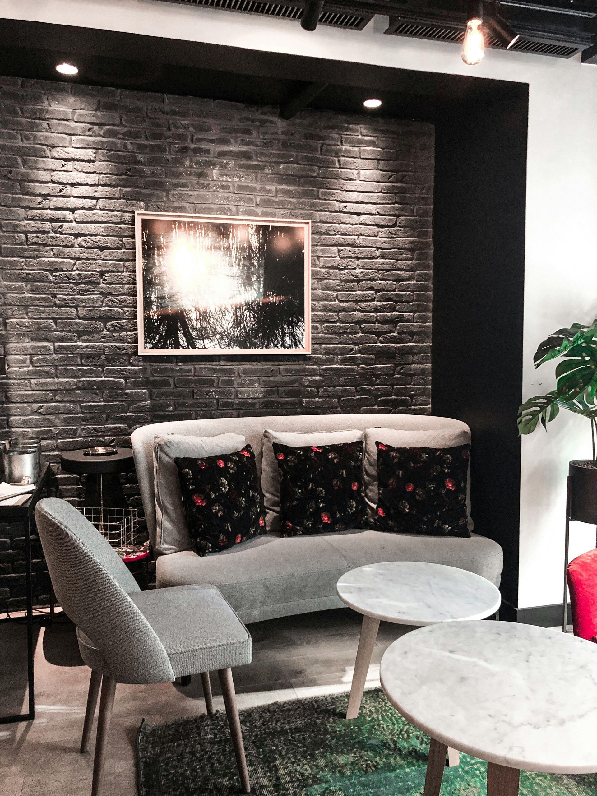 A luxe living room in Newport, South Wales with black painted brick feature and white walls. Expertly painted and decorated by Orchid Decor in Newport, South Wales.