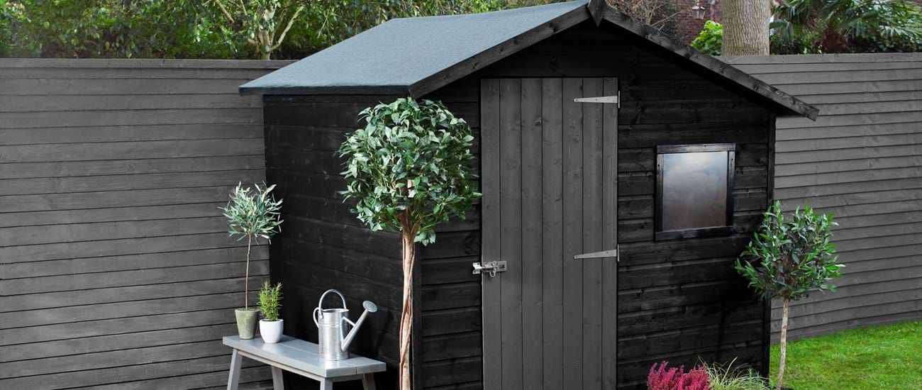 Dark charcoal black painted shed with dark grey details. In Newport, Wales. Painted expertly by Orchid Decor.