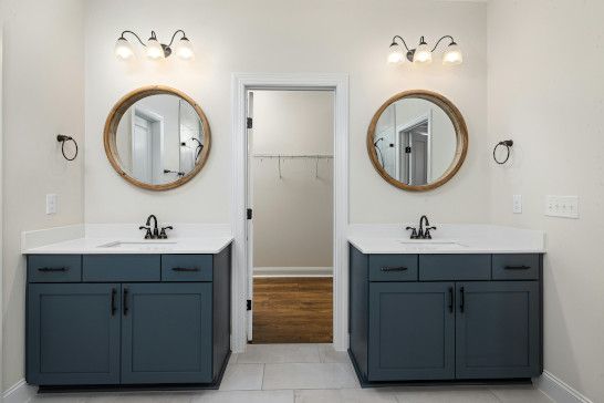 A bathroom with a scale, toilet seat, wall clock, and barometer.