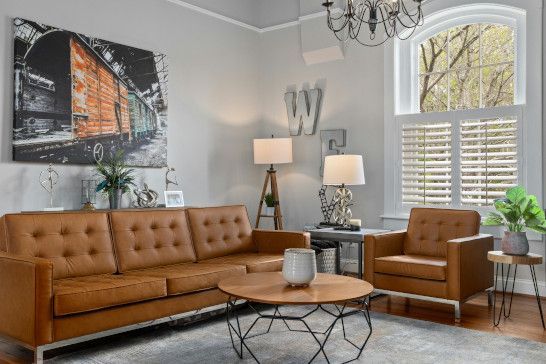 A studio couch on a patio with a window shade and dining table nearby.