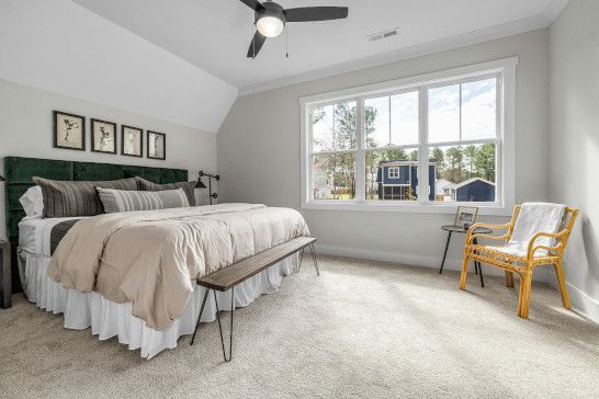 A studio couch near a sliding door, quilt, and window shade.