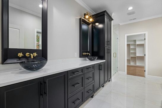 A washbasin near a medicine chest, bathtub, microwave, and tub.