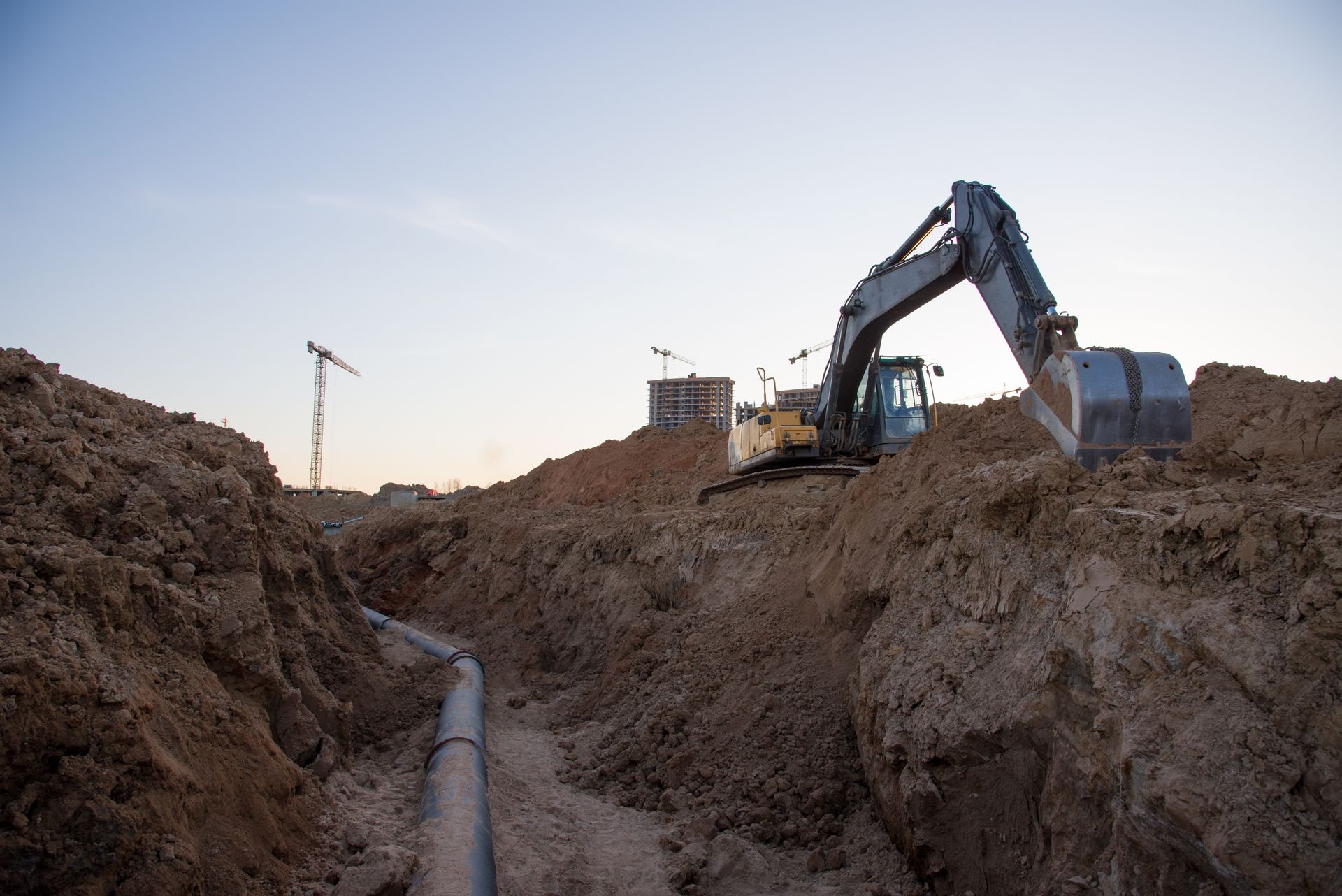 Excavator diligently trenching for the installation of external sewer pipes.