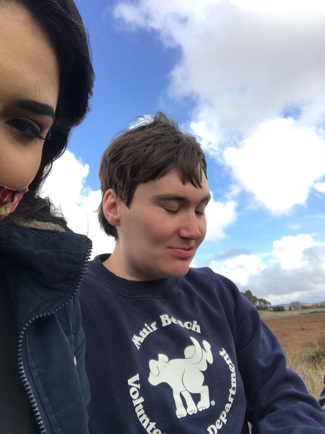 A man wearing a sweater that says axis beach on it