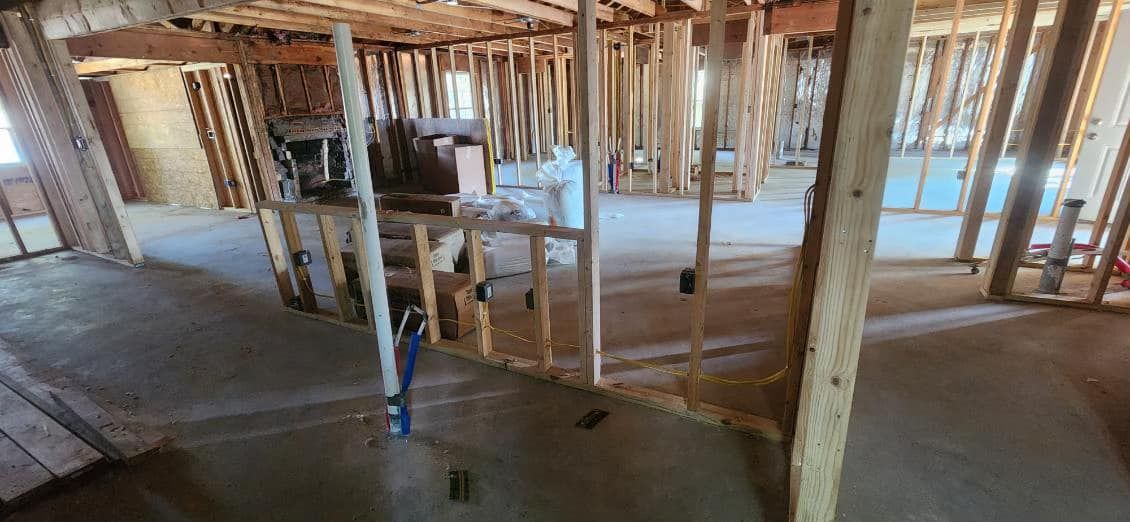 A room in a house under construction with a lot of wooden beams.