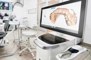 A computer monitor in a dental office with a picture of a tooth on it.