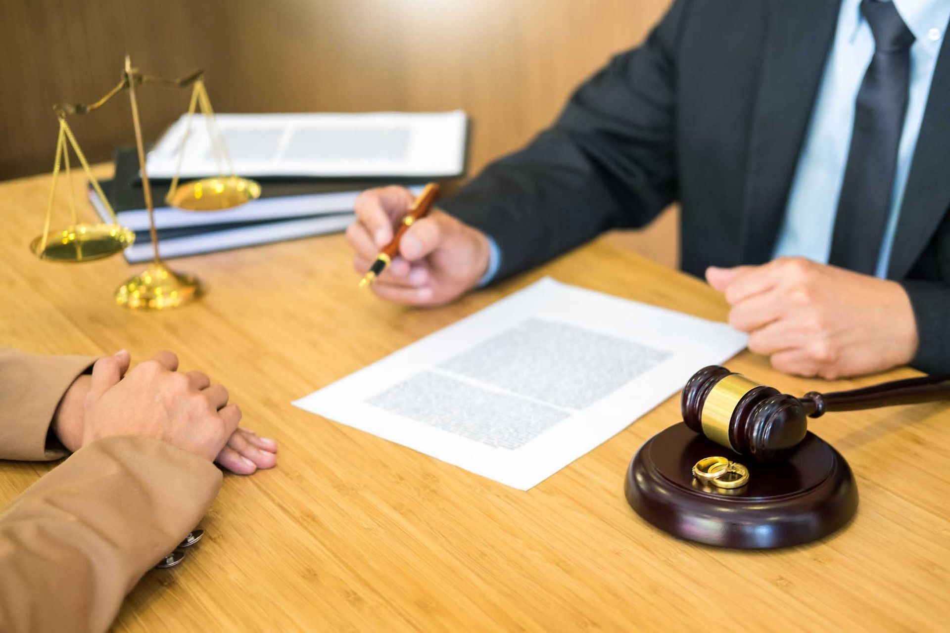 Lawyer talking to client with document on desk — Lakeland, FL — Kaylor Law Group