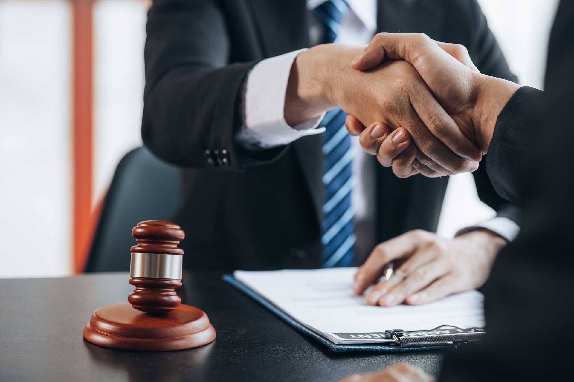 Lawyer shaking hands with client with gavel on desk — Lakeland, FL — Kaylor Law Group