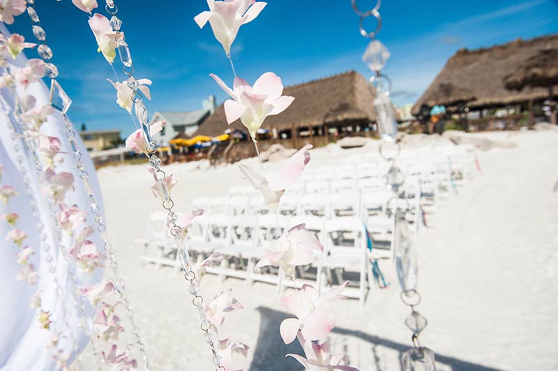 Flowers blowing in the breeze in front of large beach tiki.