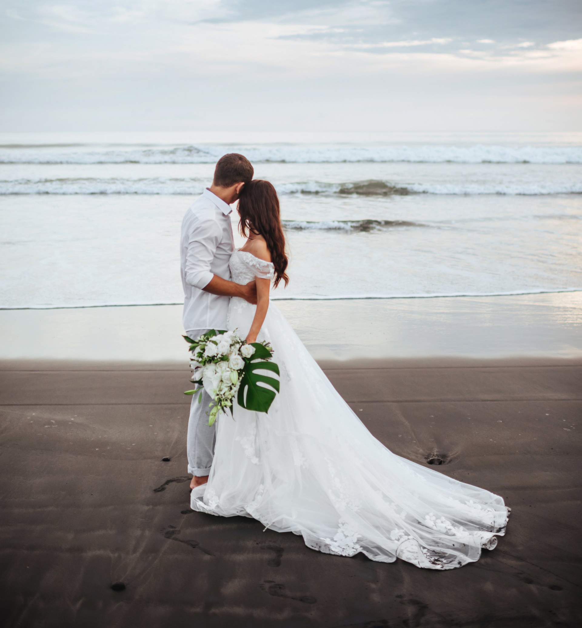 Newlyweds standing on the beach