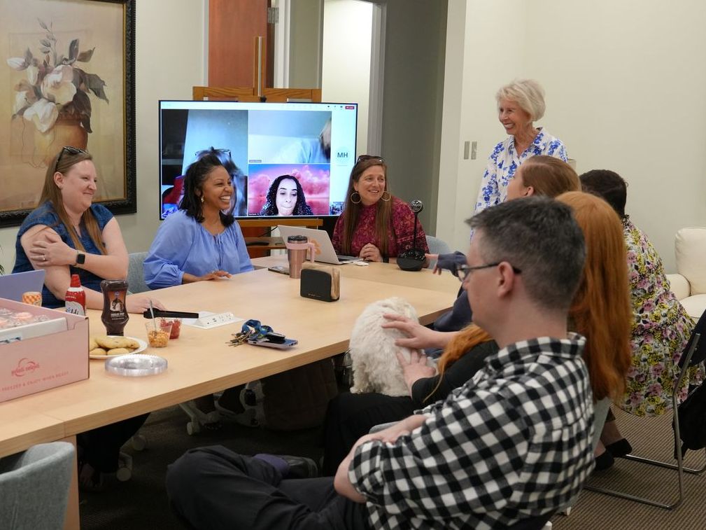 Special Needs: A group of people are sitting around a table in a conference room.