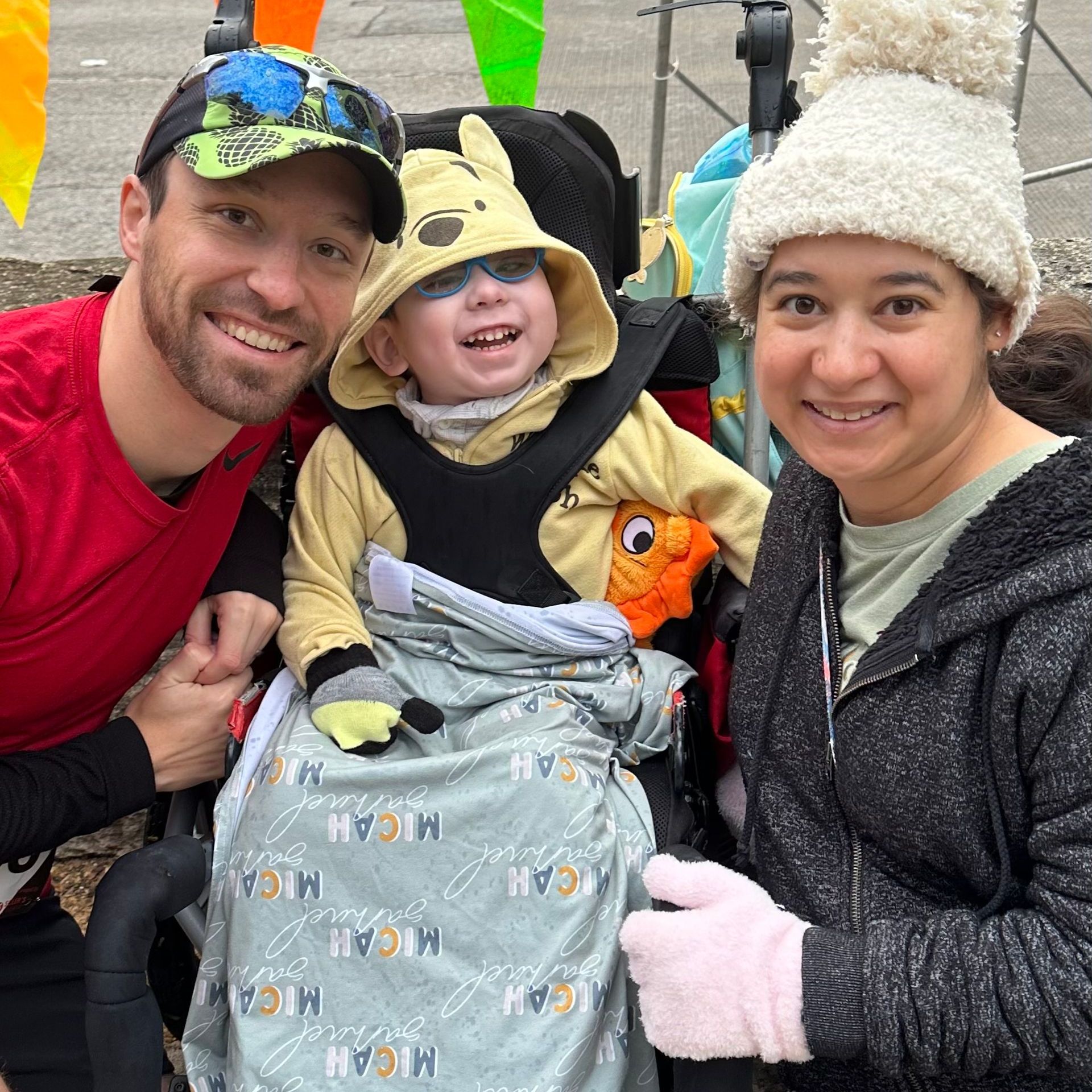 Special Needs: A man and woman are posing for a picture with a child in a wheelchair