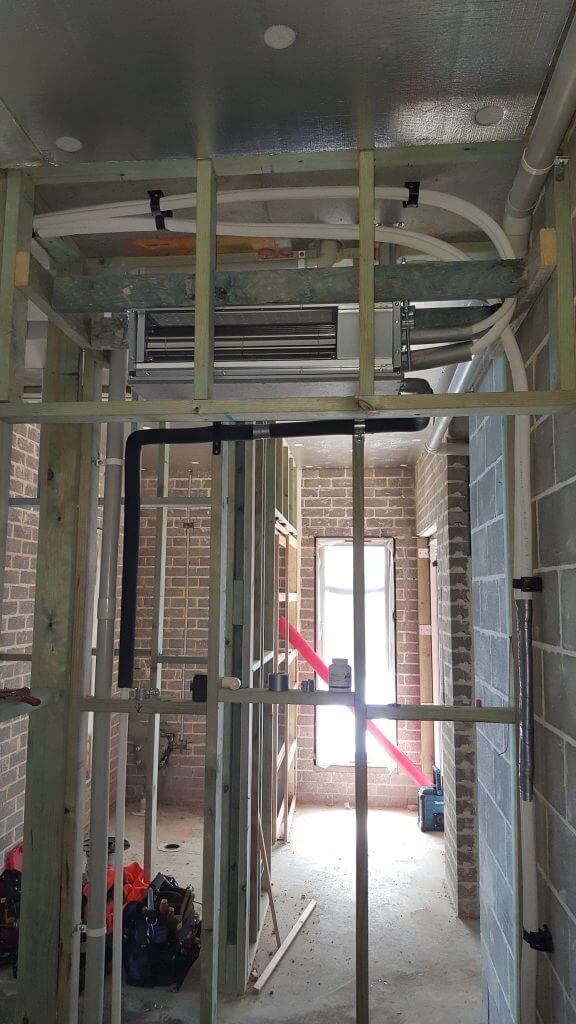 staff fitting air con on building site