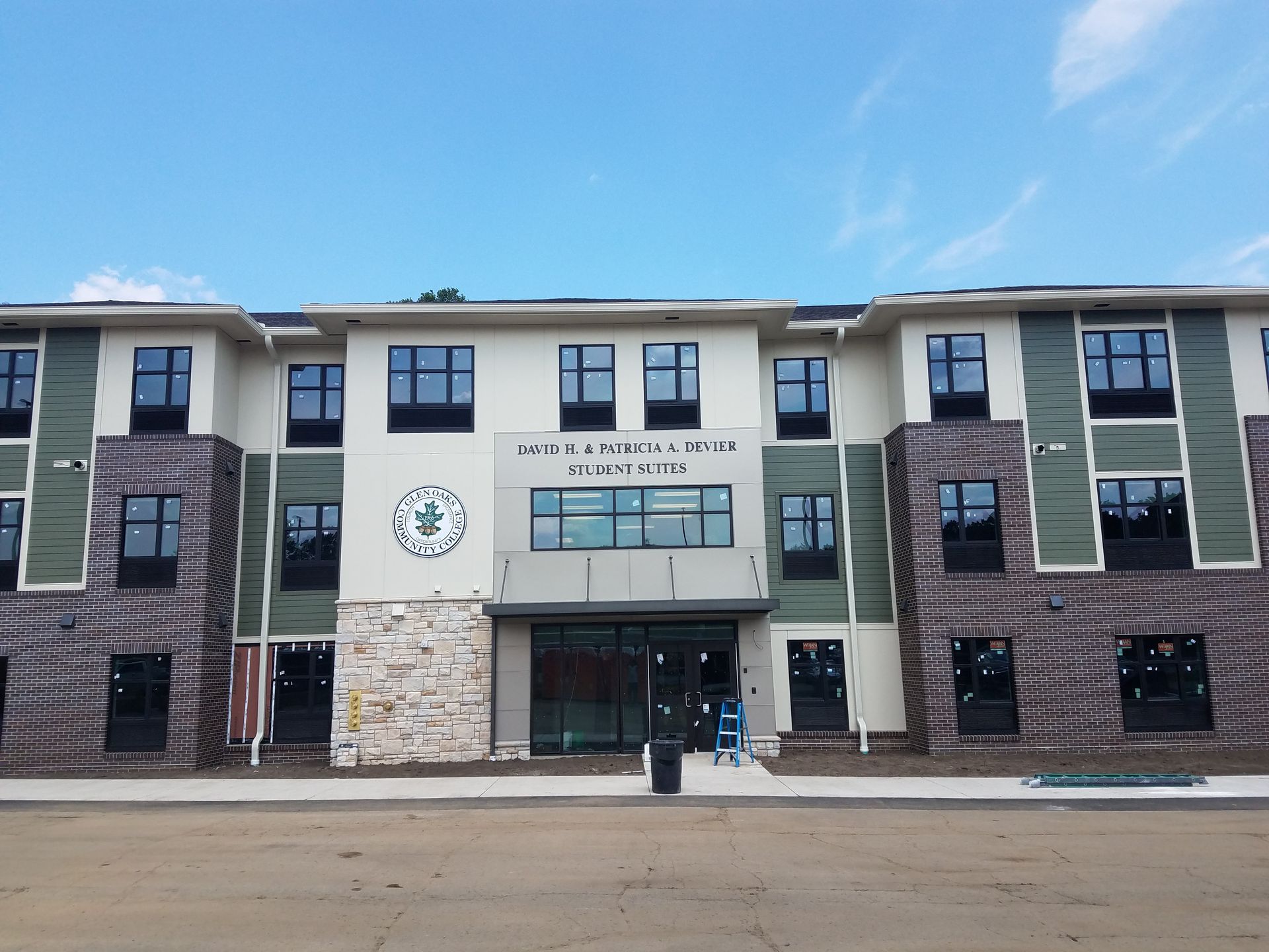 A man is painting a gutter on a roof with a brush.