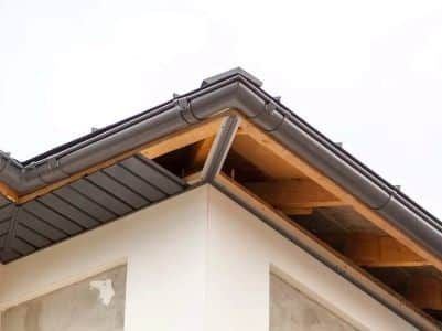 The roof of a house is being built and has a gutter on it.
