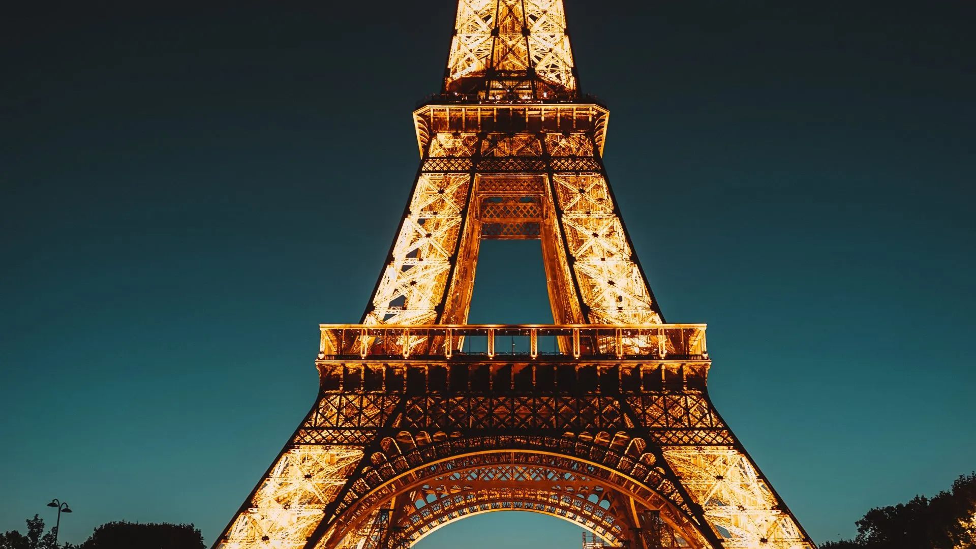 The eiffel tower is lit up at night in paris.