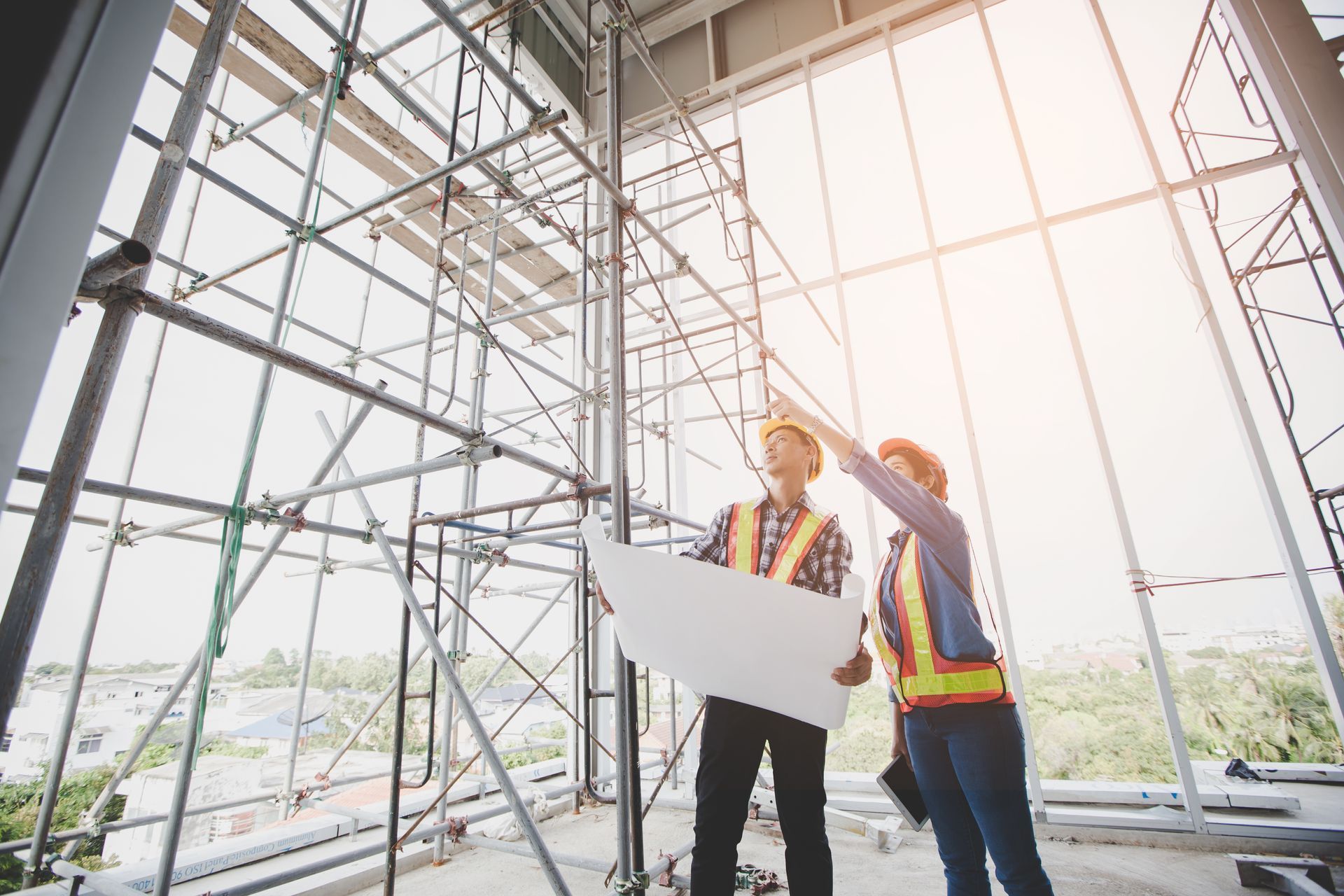 Un homme et une femme regardent un plan sur un chantier de construction.