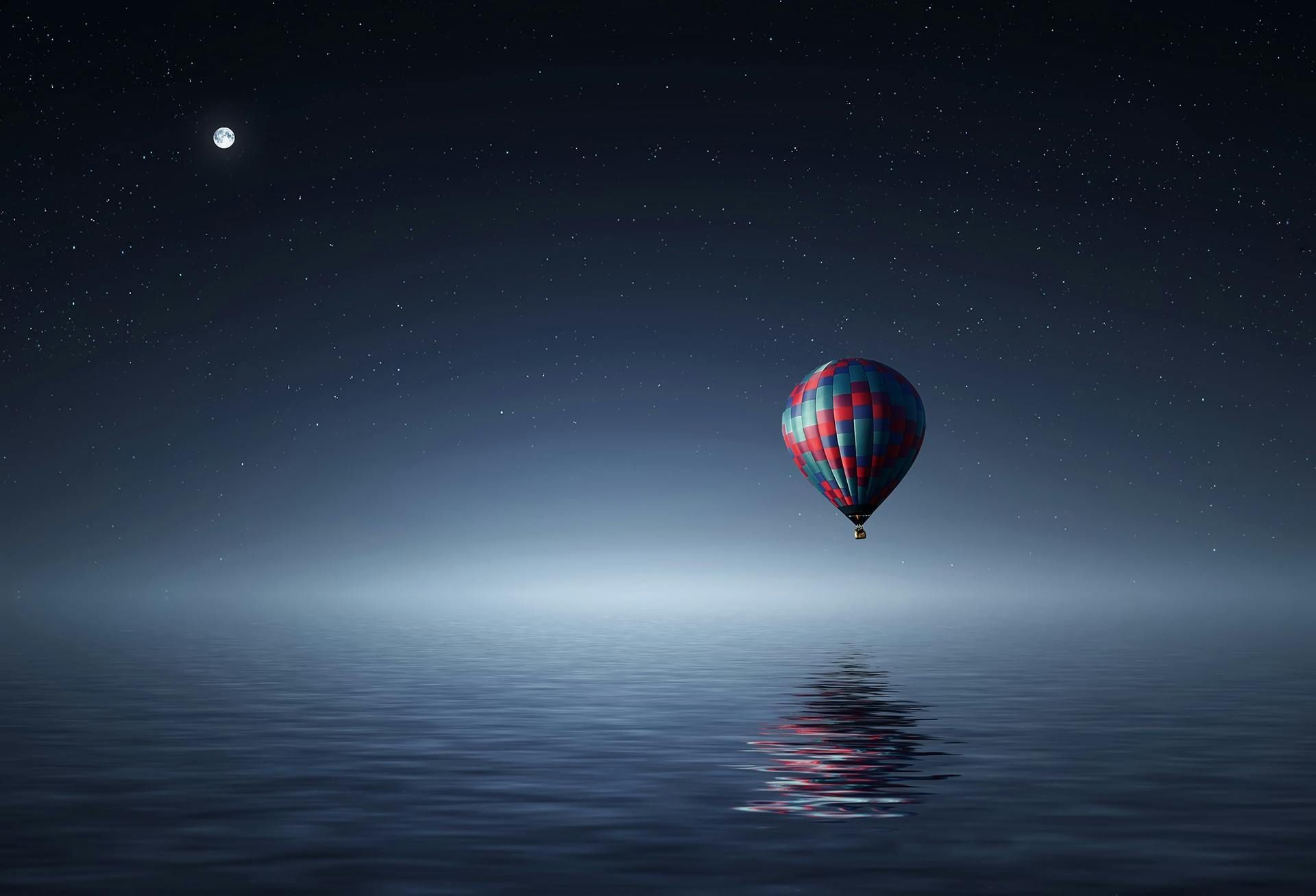 hot air balloon floating over water