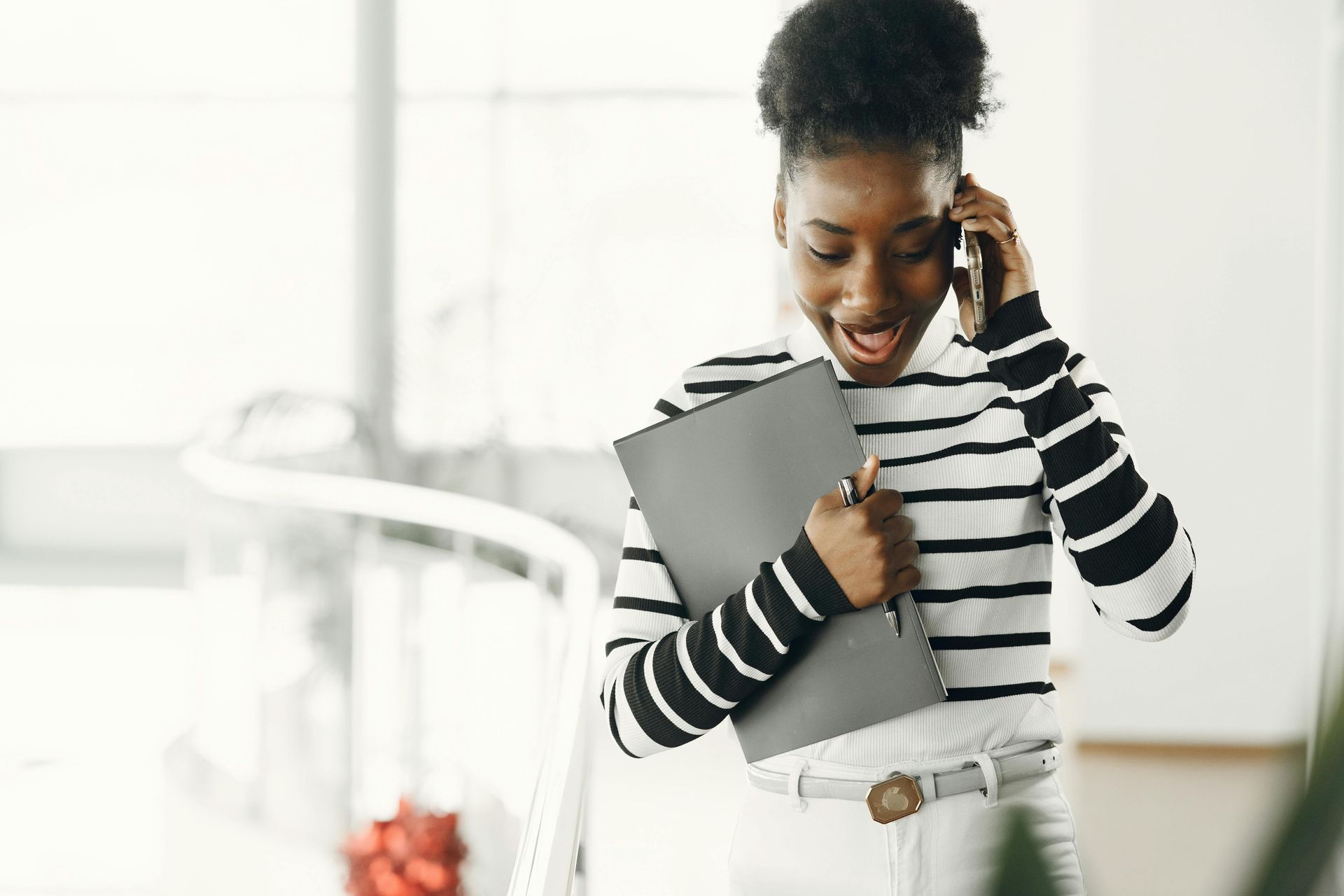 image of woman on the phone holding her computer