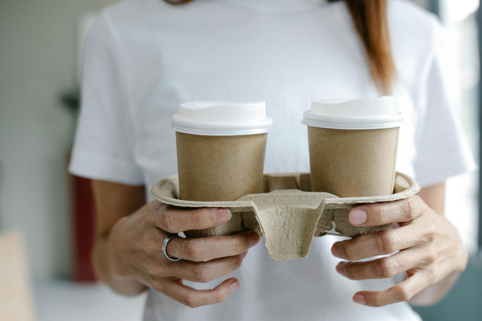 woman holding two cups of coffee