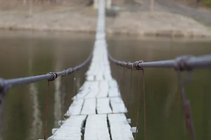 Un ponte sospeso sopra uno specchio d'acqua.