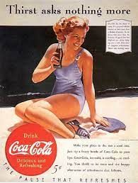 Una donna in costume da bagno è seduta sulla spiaggia e tiene in mano una bottiglia di Coca-Cola.