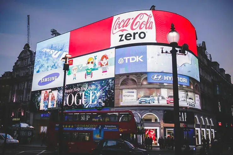 Un grande cartellone pubblicitario sul lato di un edificio che recita Coca Cola Zero.