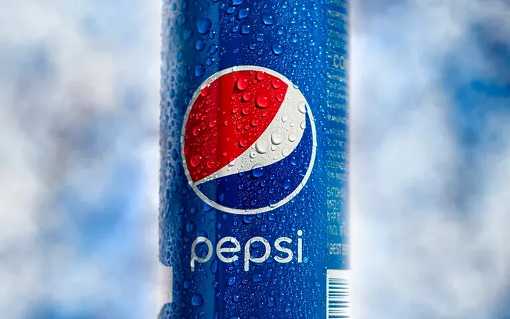 Un primo piano di una lattina di Pepsi con gocce d'acqua sopra.