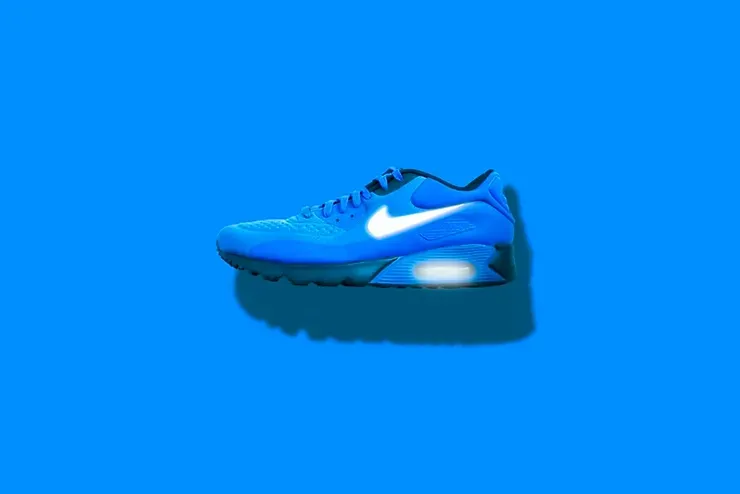 Una scarpa Nike Air Max di colore blu è appoggiata su una superficie blu.