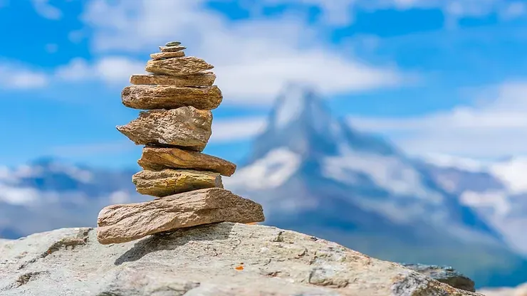 Un mucchio di rocce accatastate l'una sull'altra su una roccia con una montagna sullo sfondo.