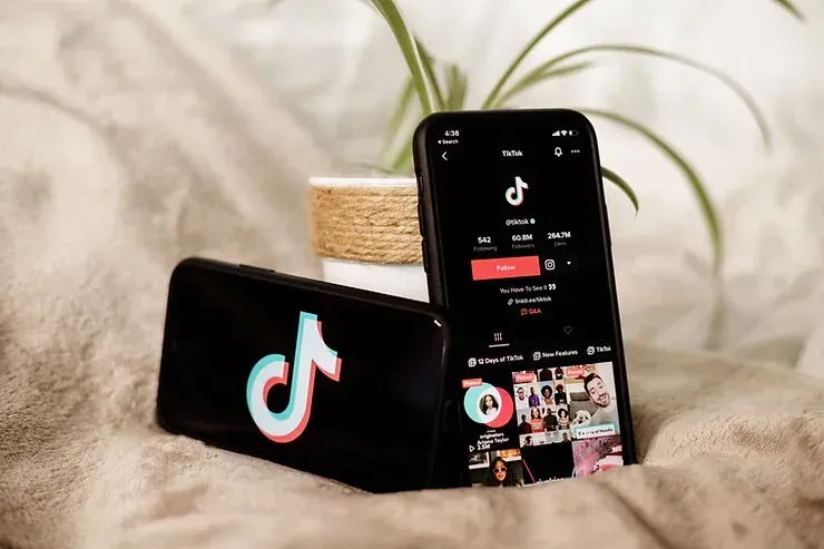 Due telefoni cellulari sono appoggiati su un letto, uno accanto all'altro.