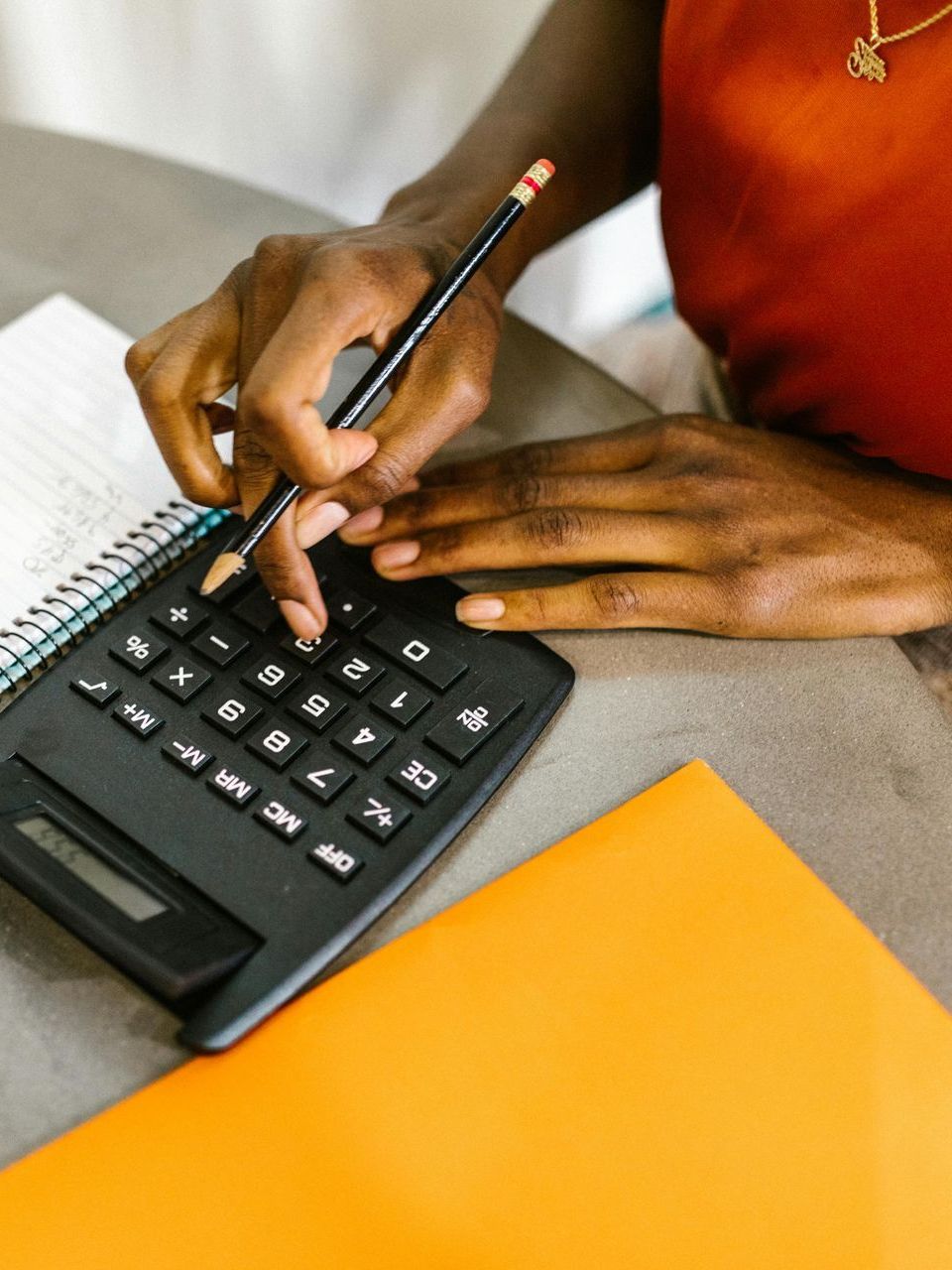 A young boy is riding a bike in a park while his parents applaud.