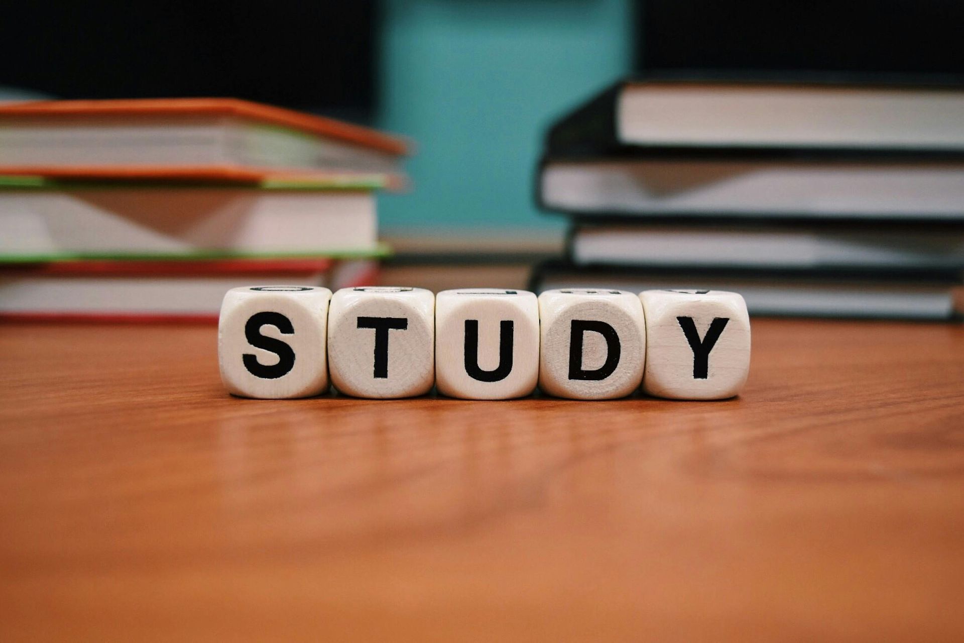 The word study is written on dice on a wooden table.