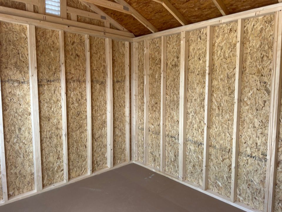 Interior corner of a shed with exposed wood framing and OSB paneling.