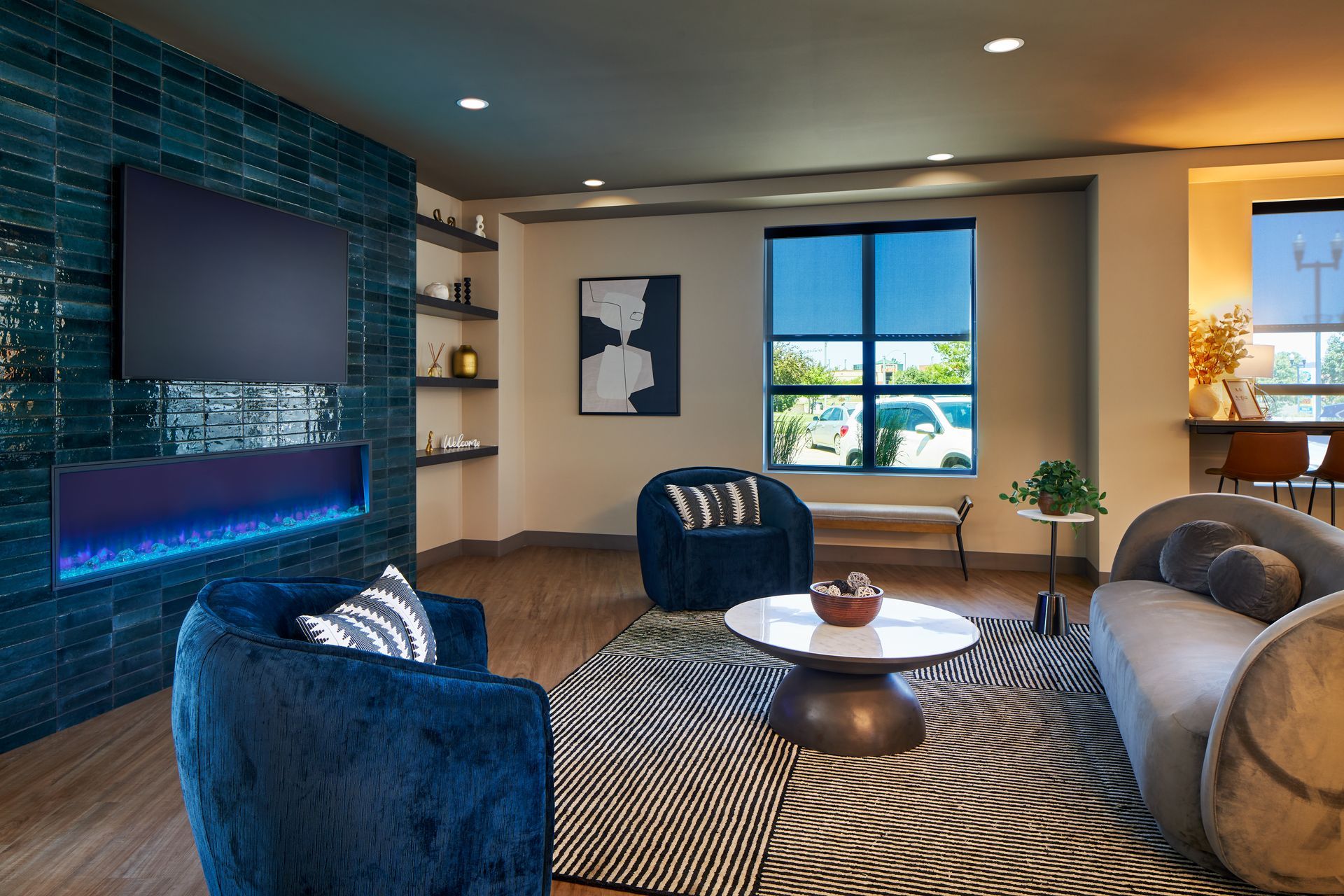 Living room with blue accent wall, fireplace, and furniture; a window and rug.