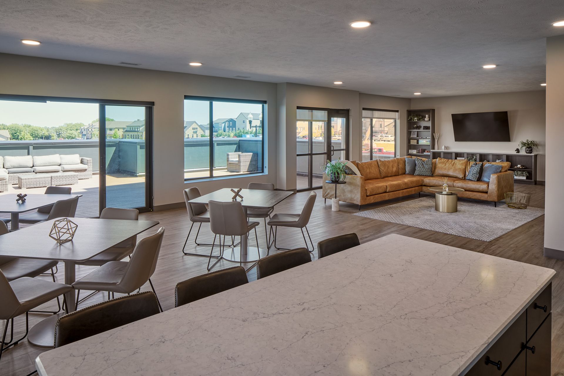 Spacious open-concept living area with dining, seating, and a kitchen island, opening to a patio.