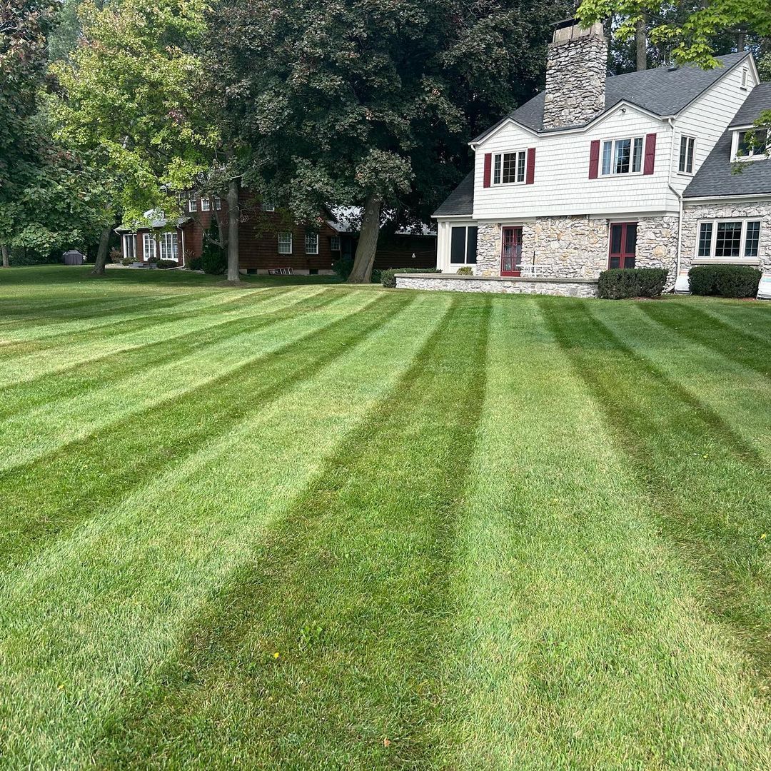 A house with a lush green lawn in front of it.