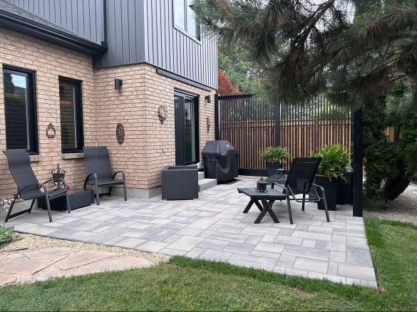 A brick house with a concrete walkway leading to it.