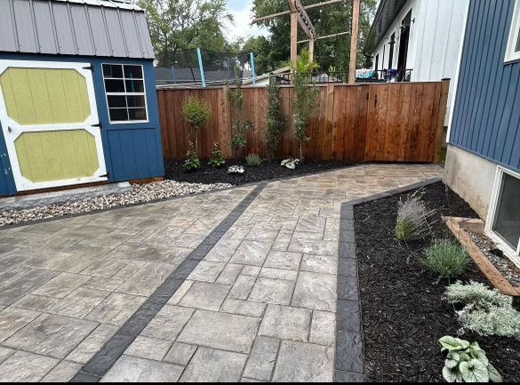 A brick walkway surrounded by flowers in a garden.