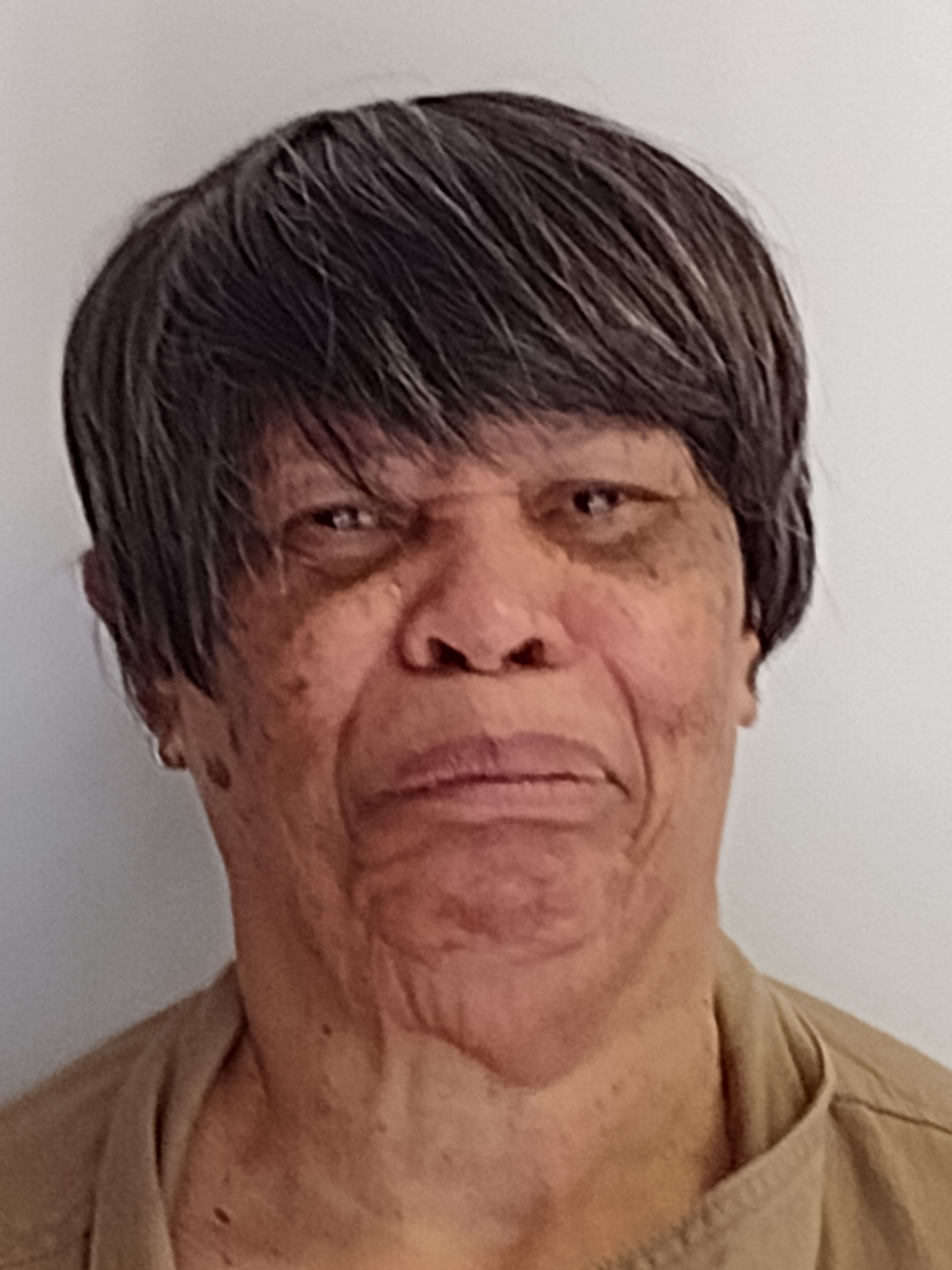 A close up of an older woman 's face with a serious look on her face.