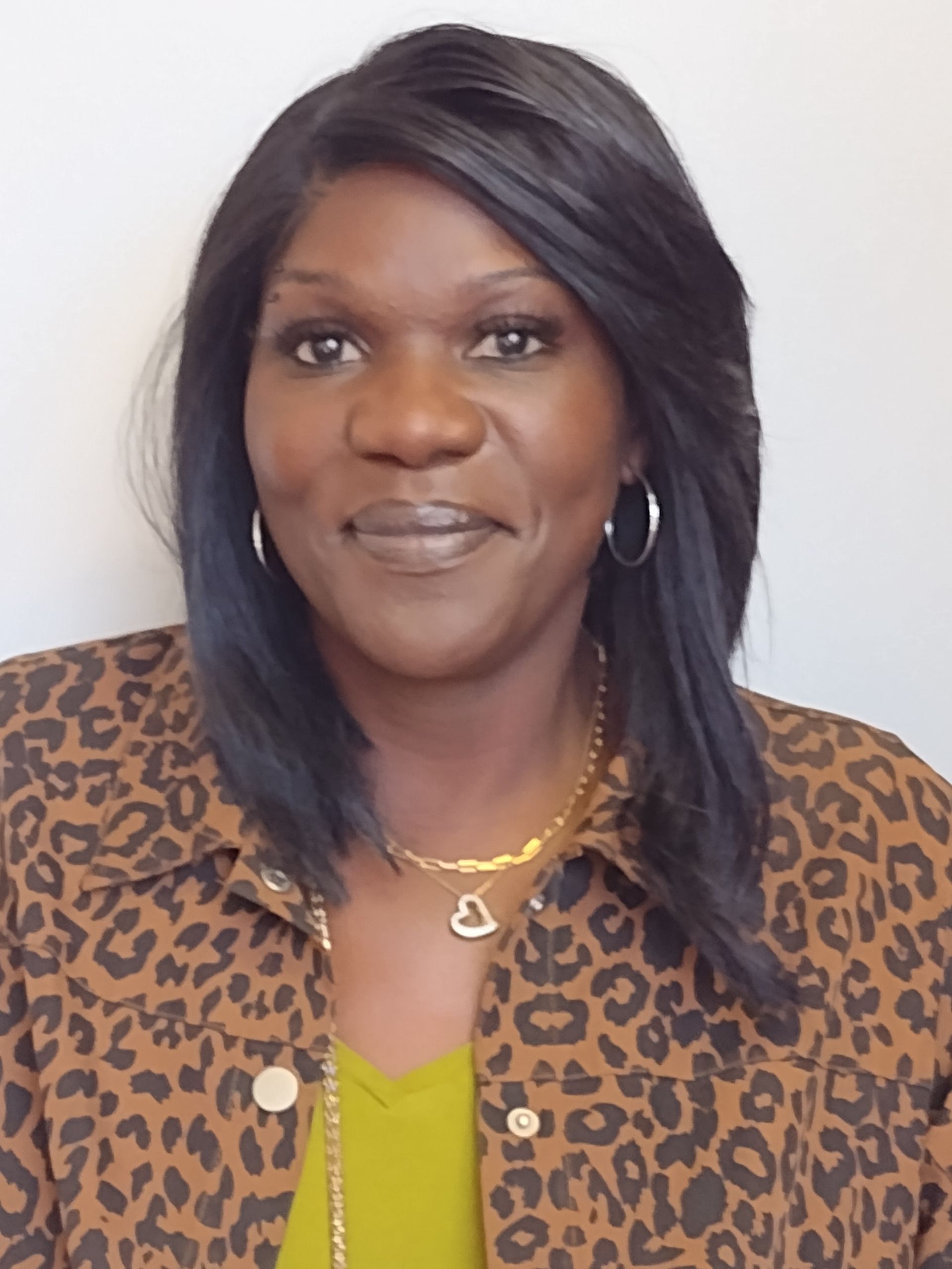 A woman wearing a leopard print jacket and a heart necklace